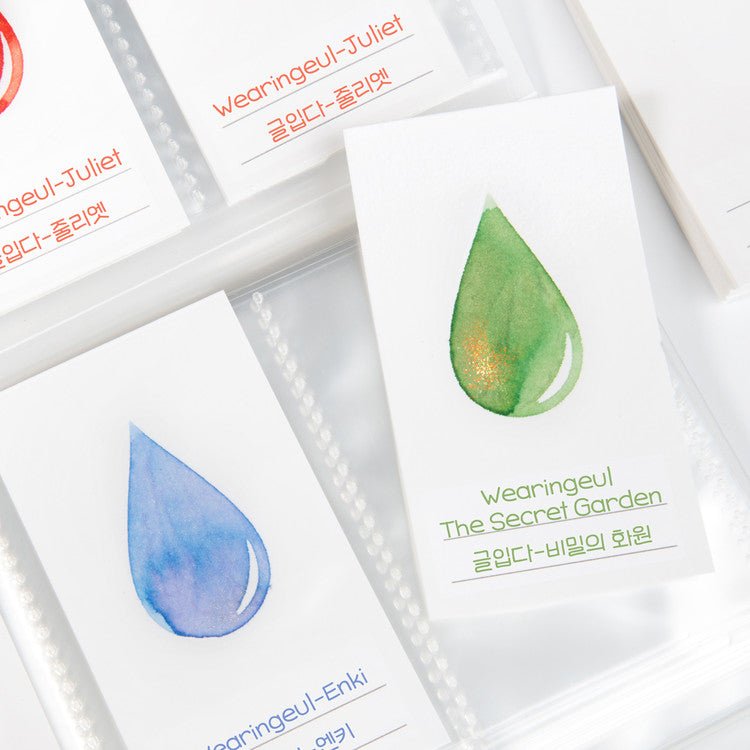 Wearingeul Ink Drop Swatch Cards feature watercolor drops and brand names in English and Korean, ideal for showcasing fountain pen ink characteristics. Pack of 50, 5x9 cm each.