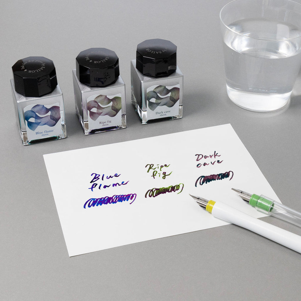 Dipton Ink Dark Cave - 20ml by Sailor, shown with Blue Flame and Ripe Fig inks. Includes handwritten swatches and two fountain pens, emphasizing dip pen compatibility.
