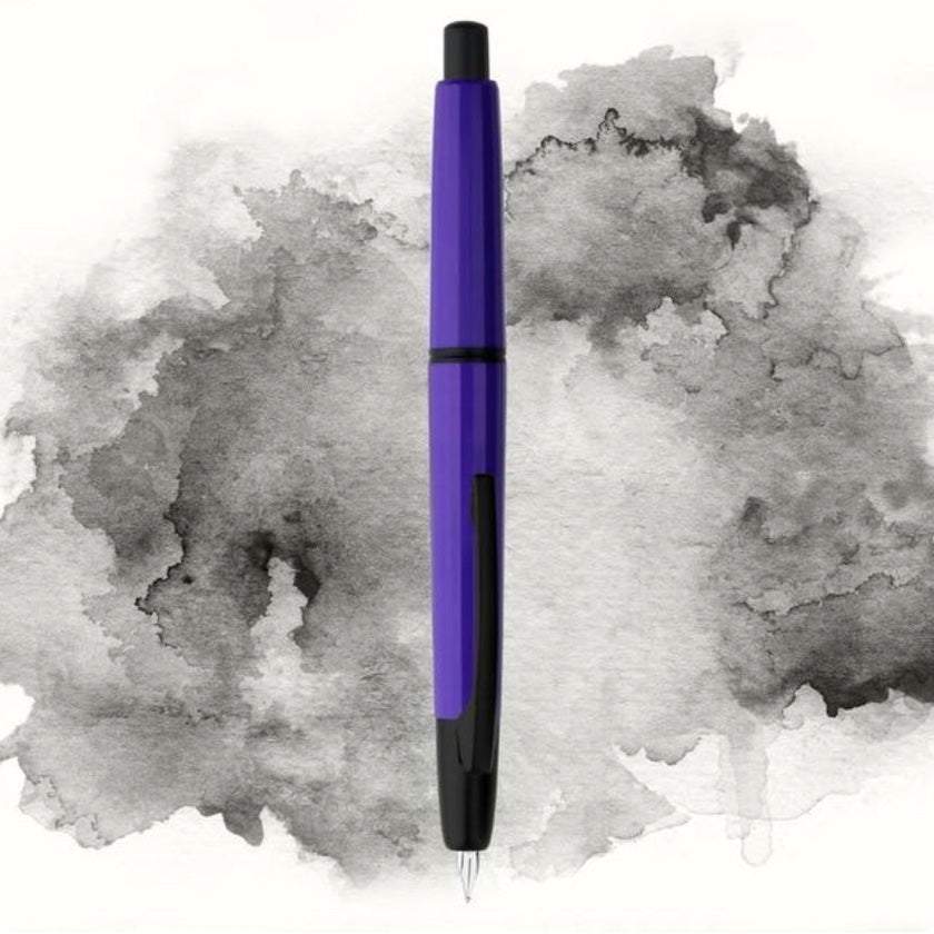 Moonman/Majohn A2 fountain pen, violet with black clip, extra fine nib, click-retractable, displayed vertically on ink splash background.