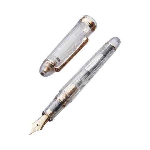 Uncapped #3776 Century Nice Rose Gold fountain pen with transparent barrel, gold-tone trim, and medium 14K gold nib, showcasing its elegant design and unique features.