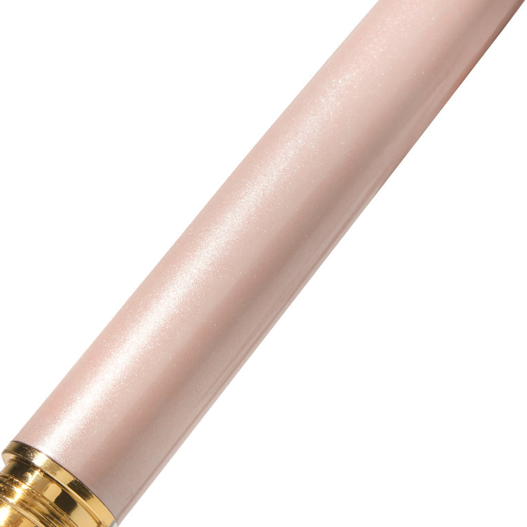 The Bijou Fountain Pen - Huffin Puff Pink (Fine) in a metallic pink tube with a gold band, showcasing intricate brass details and shimmering finish.