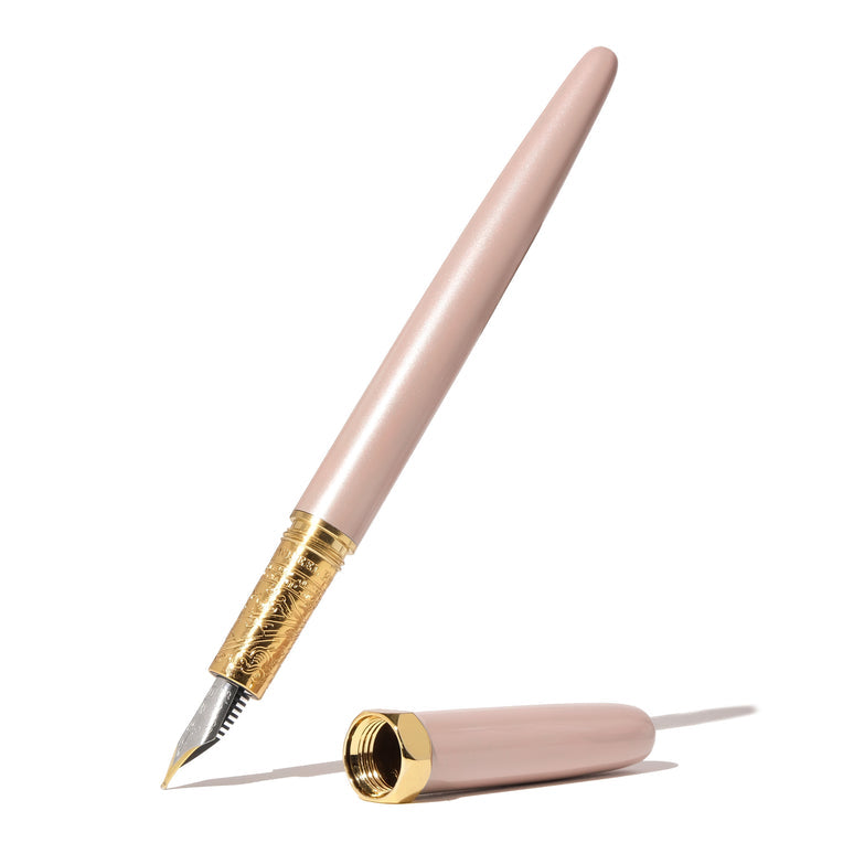 The Bijou Fountain Pen - Huffin Puff Pink (Fine) from Ferris Wheel Press, features a blush lacquer barrel, gold-plated grip, and detailed brass craftsmanship. Cap displayed separately.