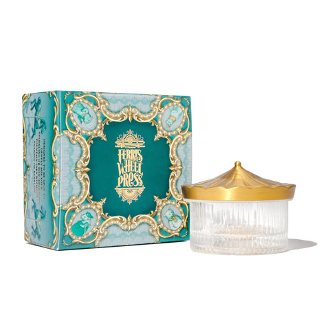The Carousel Inkwell - Polished Edition features a ribbed glass jar with a gold carousel lid, paired with an ornate teal and gold box.