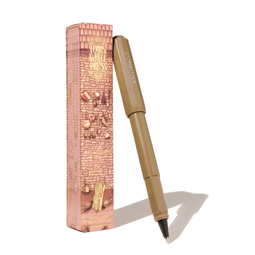 Ferris Wheel Press Roundabout Rollerball Pen - Oinking Embers, featuring a warm peanut-brown brush tip, with decorative packaging in muted reds and golds.
