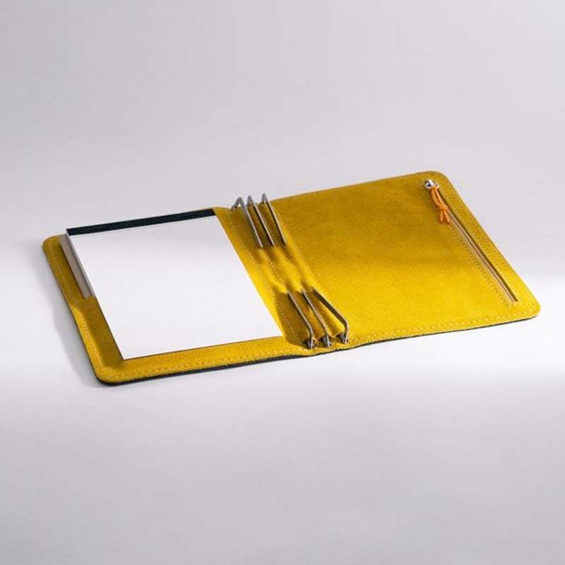 Roterfaden Taschenbegleiter SO_22 portfolio in Smoke Blue/Honey open flat, showcasing a lined notepad, pen loops, and a zippered pocket on a table.