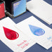 Wearingeul Ink Drop Swatch Cards featuring red Dracula and blue Enki ink samples, with corresponding fountain pen ink bottles, on a smooth, coated paper for optimal ink display.