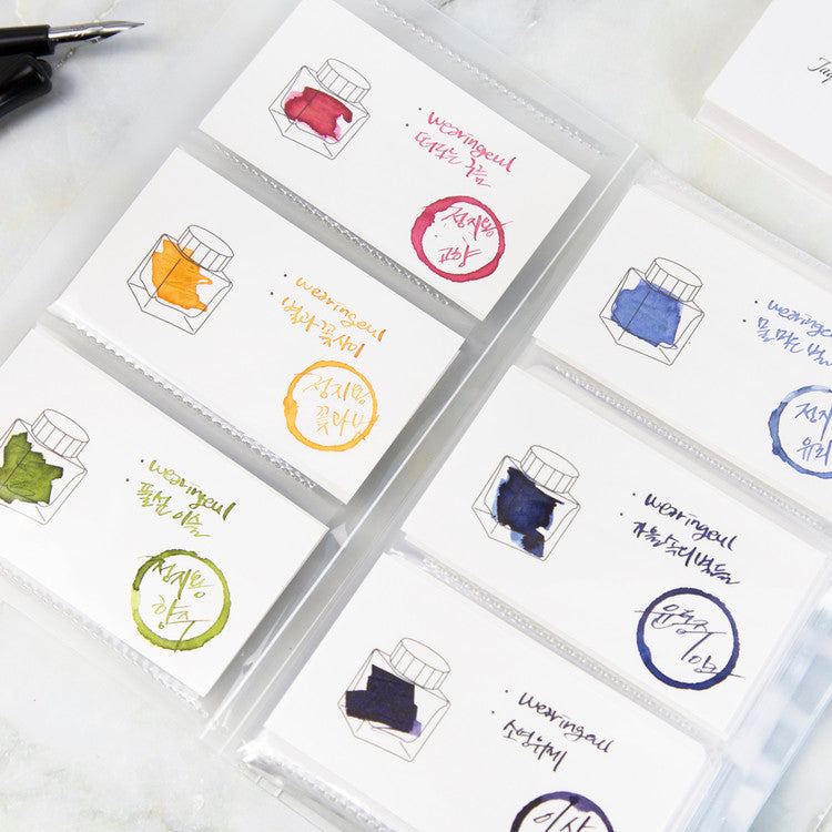 Wearingeul Ink Swatch Card Binder with ink swatch cards in clear sleeves, featuring handwritten Korean text and a dip-pen nib, ideal for organizing fountain pen ink collections.