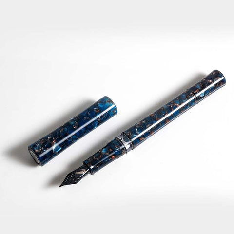 Blue Scepter (Vacuum) - Broad fountain pen by Fine Writing International, featuring a marbled blue-and-black design with a stainless steel nib, cap removed, revealing the nib.