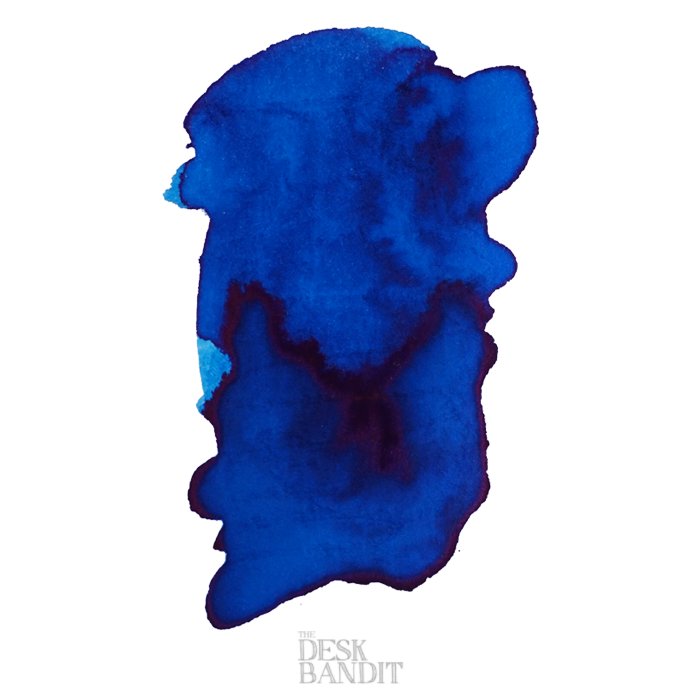 Abstract blue ink swatch labeled The Desk Bandit, showcasing the 2ml sample of Robert Oster's Blue Water Ice dye-based ink.