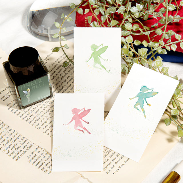 Wearingeul Tinker Bell Ink Swatch Cards displayed with fairy-themed ink, notecards, and writing accessories, showcasing pastel silhouettes on fountain pen friendly paper.