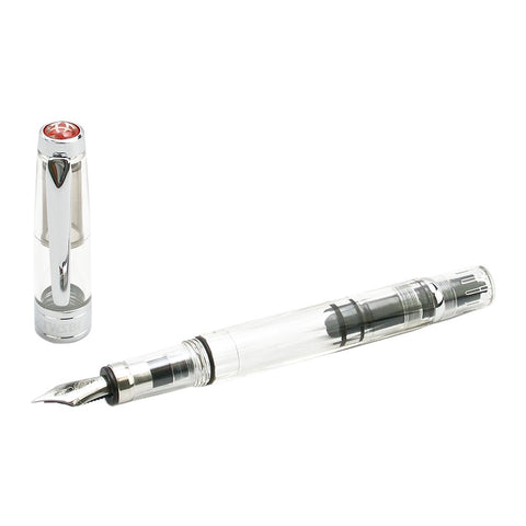 Diamond 580 (Clear) - Stub 1.5 fountain pen with transparent body, visible piston-filling mechanism, stainless-steel nib, and silver-toned cap beside it.