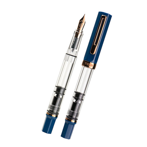 TWSBI ECO fountain pen in Indigo Blue with bronze trim, featuring a clear barrel and visible piston mechanism. Includes one capped and one uncapped pen, fine nib.