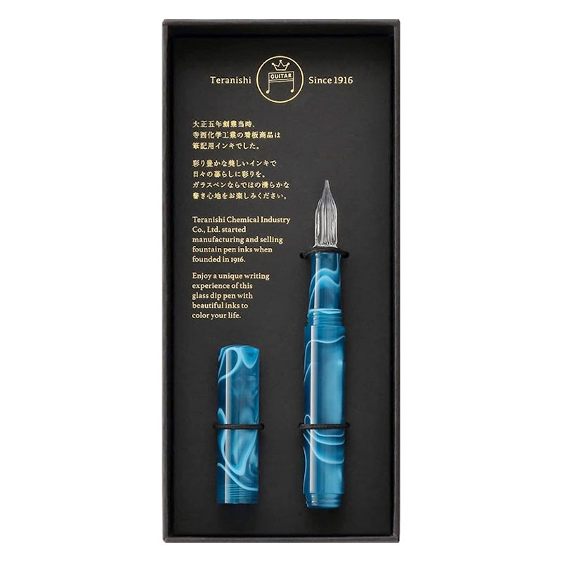 Teranishi Glass Pen (Peacock Blue) set features a swirled-blue acrylic handle with a clear-glass nib and matching cap, presented in a branded black box.