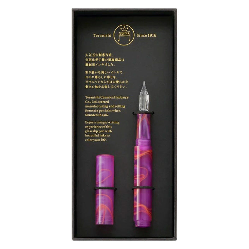 Teranishi Glass Pen (Sunset Pink) in a black tray, featuring a swirled purple-and-orange resin barrel with a clear glass nib, presented in a boxed set.