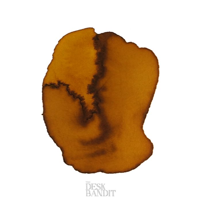 Green Olive - 2ml ink swatch on paper, showing warm golden-brown tones with sepia feathering, featuring THE DESK BANDIT watermark, indicating an ink sample.