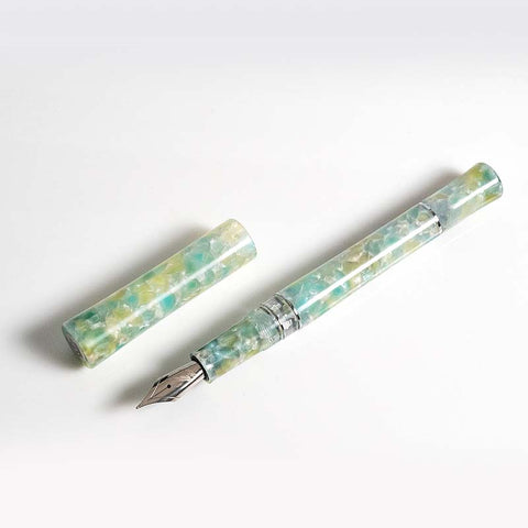 Fine Writing International Green Scepter fountain pen in marbled pearlescent resin, featuring a silver-toned broad steel nib and piston mechanism, cap removed.