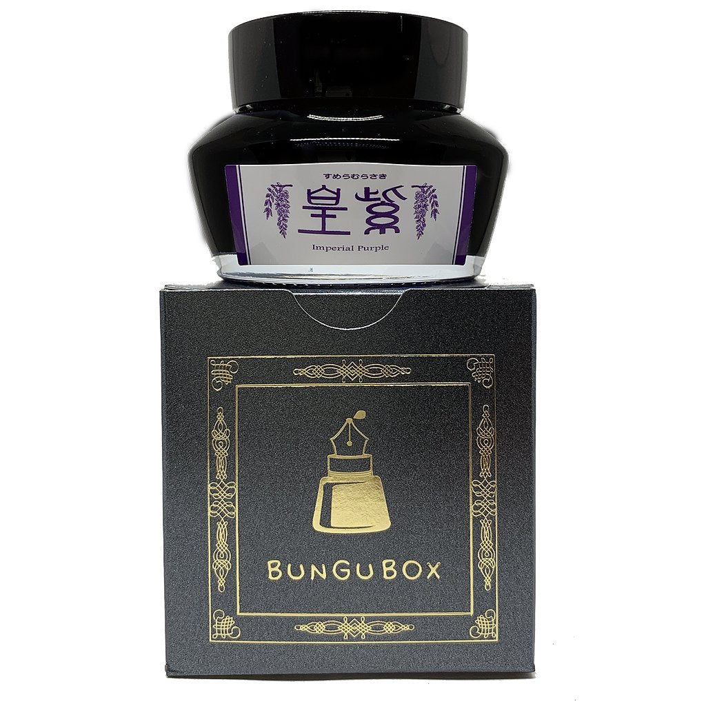 Bungubox Imperial Purple fountain-pen ink bottle atop its black and gold packaging, highlighting the 50ml dye-based ink's elegance and specialty branding.