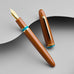 Esterbrook Estie - Incredible Rock / Gold - Broad fountain pen, disassembled; features glossy burnt-orange barrel, turquoise ink band, and gold-plated nib and clip.
