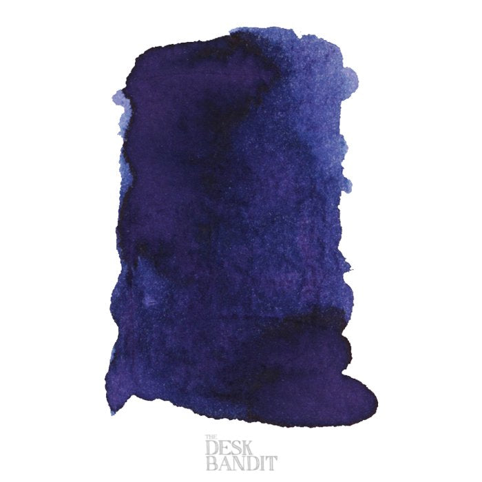 Midnight Sapphire - 2ml ink sample featuring a dark blue–purple, granulating swatch on a white background, branded faintly with THE DESK BANDIT.