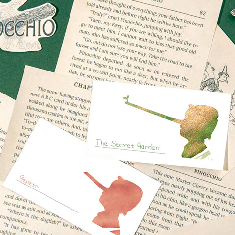 Wearingeul Pinocchio Ink Swatch Cards, featuring Pinocchio-themed silhouettes, displayed on an open book page from “Pinocchio.” Includes 50 fountain pen friendly cards for ink swatching.