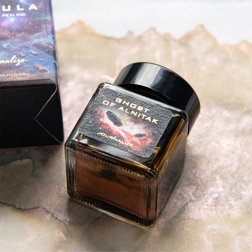 Ghost of Alnitak (Shimmer) - 30ml: A square glass bottle of coppery-brown, shimmering fountain pen ink by Journalize, featuring a decorative outer box.