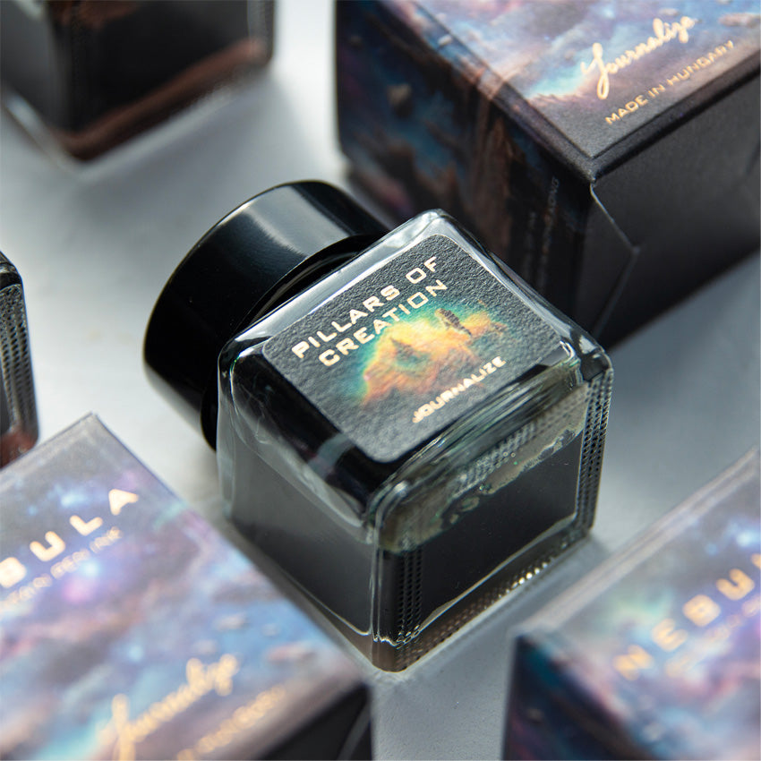 Journalize Pillars of Creation Shimmering Fountain Pen Ink, 30ml. Close-up of square glass bottle with nebula design, part of the Starry Night series.