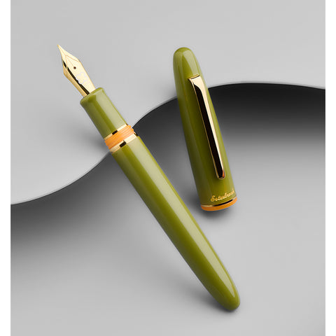 Esterbrook Estie fountain pen in Quirky Leaf with gold trim, medium nib, uncapped on a gray background, showcasing its polished gold nib and vintage-inspired design.