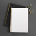 Wearingeul Reservoir Ring Note - A5 (Ruled) notebook with gold wire coil and fountain pen friendly paper, accompanied by two gold binder clips on a dark surface.