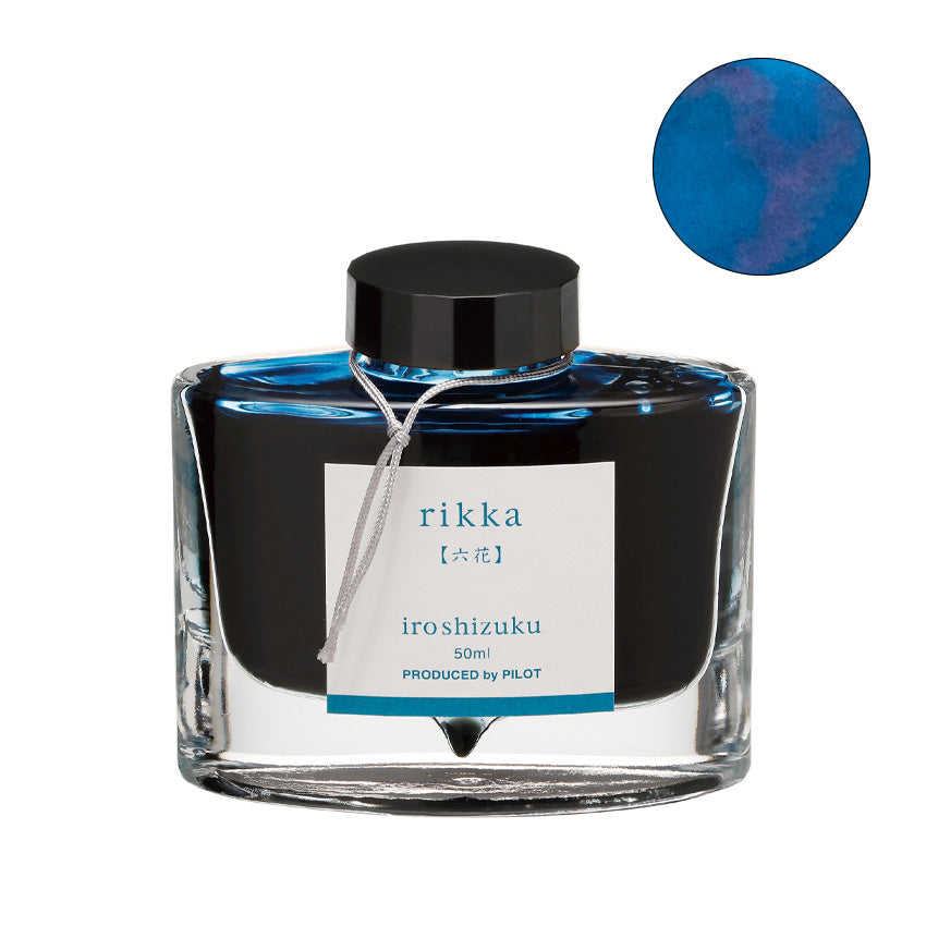 Pilot Iroshizuku Ink - Rikka - 50ml: Glass bottle of blue-teal fountain pen ink with label and cord, reflecting Japanese landscape beauty.