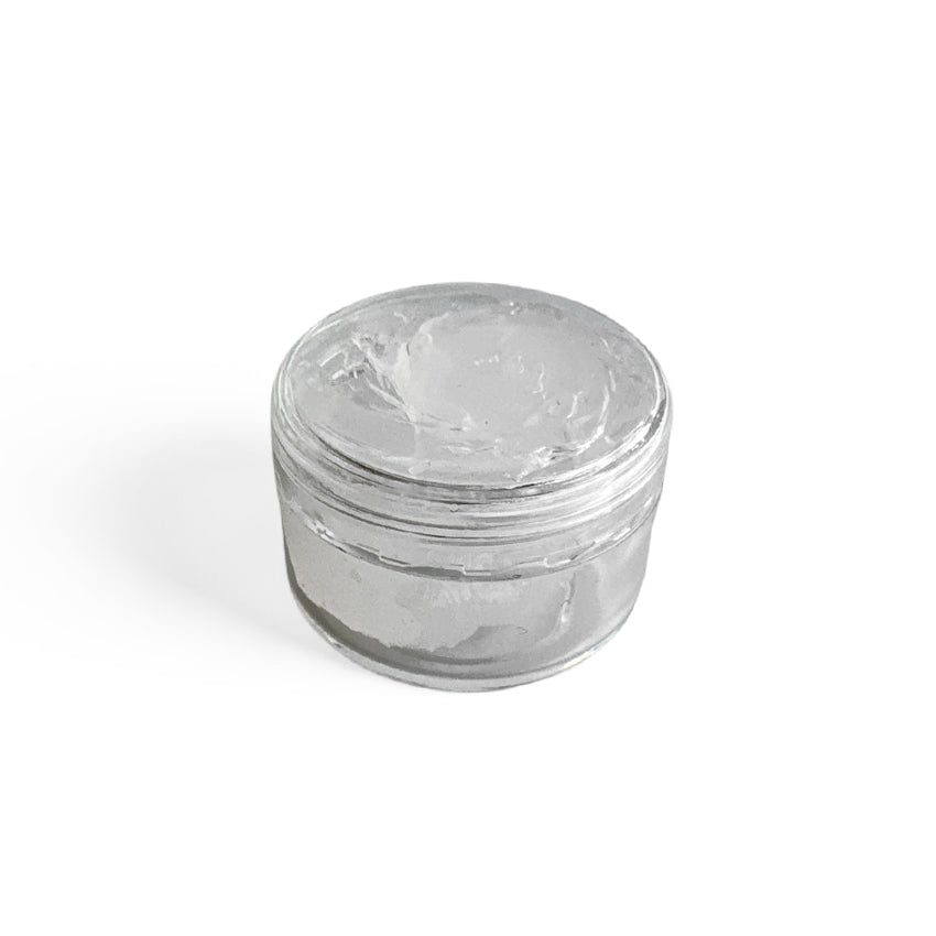 Clear glass jar filled with 100% food grade silicone grease with a lid on a white background