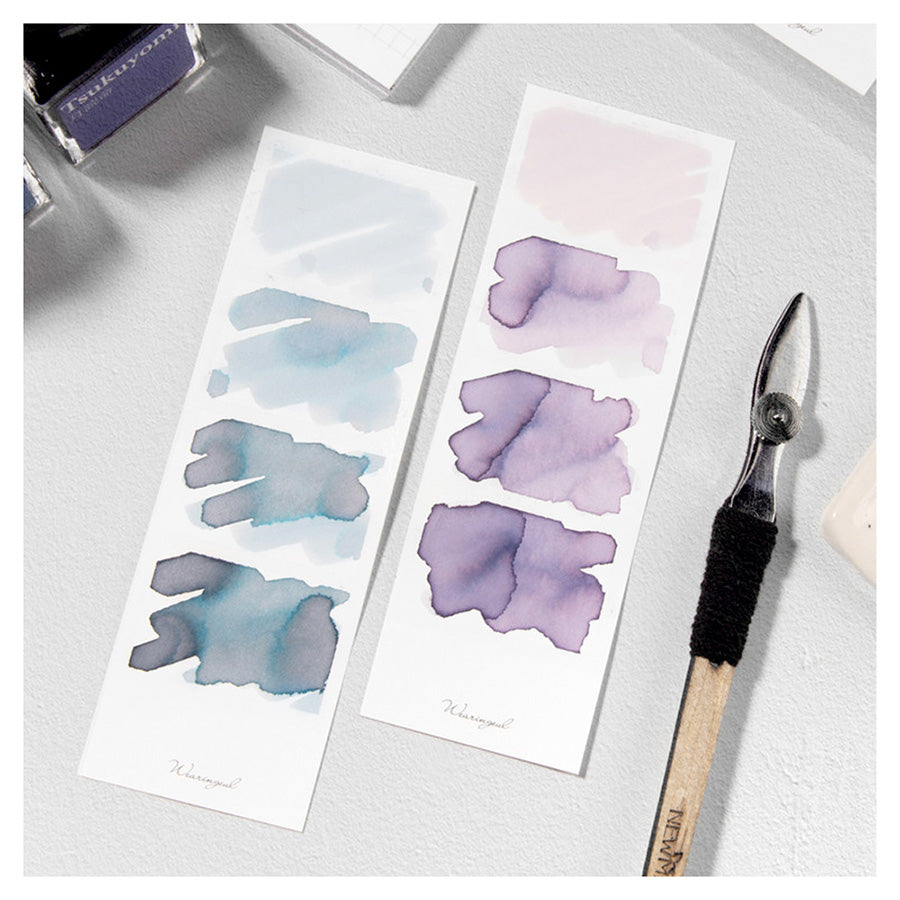 Wearingeul Four Photos Color Swatch (30 Sheets, White) with ink blobs on swatch strips, a glass-nib dip pen, and ink bottles, ideal for fountain pen ink comparisons.