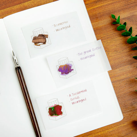 Wearingeul Tracing Ink Swatch Cards (Horizontal) with ink sketches and a dip pen on a wooden table, showcasing ink characteristics for fountain pen enthusiasts.