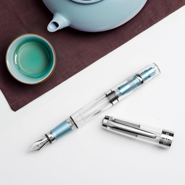 TWSBI Diamond 580 ALR (Iceberg) - Extra Fine fountain pen with clear body, light blue trimmings, and visible piston-filling mechanism, showcased on a white surface.