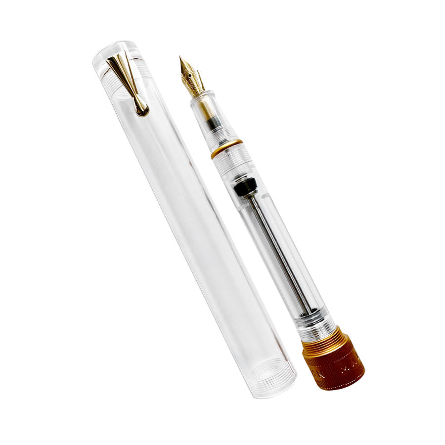 Moonman/Majohn V1 (Demonstrator/Gold) - Fine fountain pen with clear barrel, vacuum filling, and gold nib. Cap beside, showcasing piston mechanism.