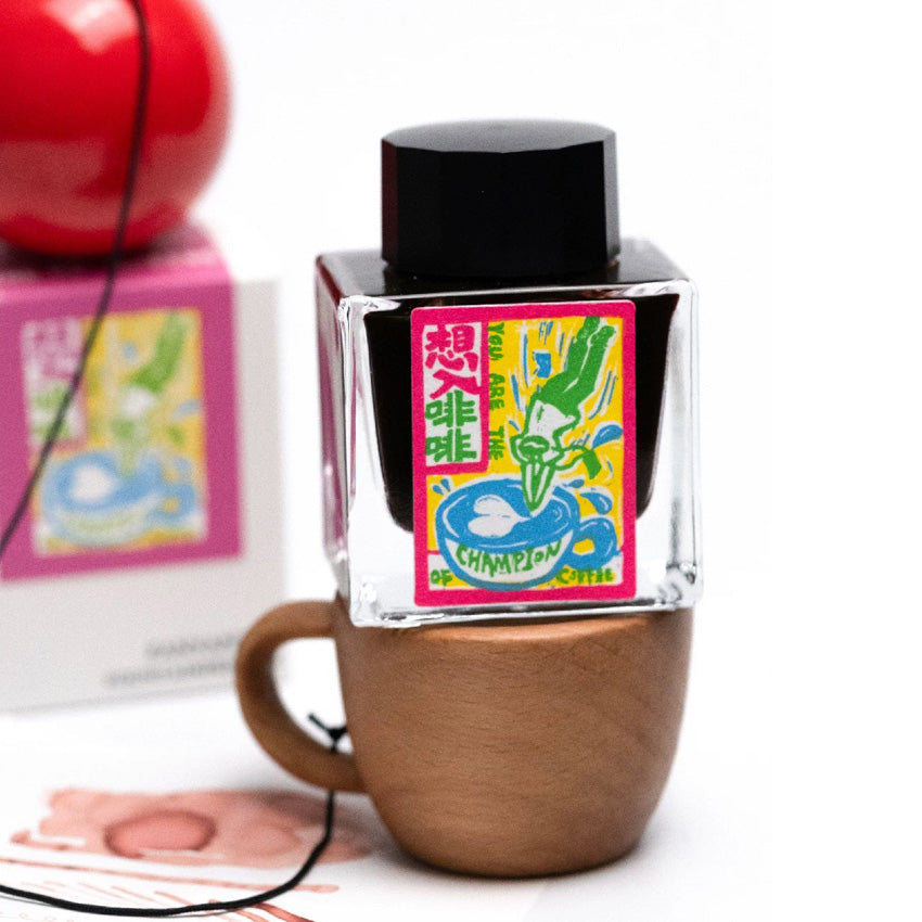 Wandering Into Coffee - 2ml fountain pen ink by Fanyantan x FLOWS12; dark liquid in a square glass bottle with neon artistic label, nestled in wooden display cup.