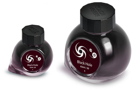 Two glass bottles of Colorverse Black Hole ink, 65ml and 15ml, with octagonal caps and galaxy swirl labels, from the Astrophysics Collection.