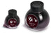 Two glass bottles of Colorverse Black Hole ink, 65ml and 15ml, with octagonal caps and galaxy swirl labels, from the Astrophysics Collection.