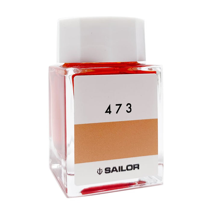Square glass bottle of Sailor Ink Studio #473, showcasing a reddish-orange dye-based ink, capped with white, offering 2ml of expertly curated color.