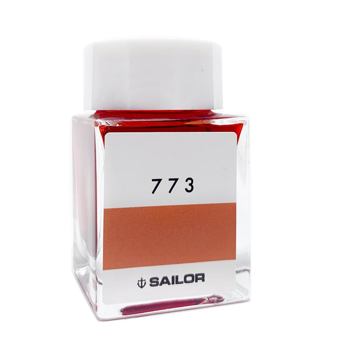 Sailor Ink Studio #773 - 2ml glass bottle, square-shaped, contains visible reddish-orange dye-based fountain pen ink, labeled with number “773” on the front.