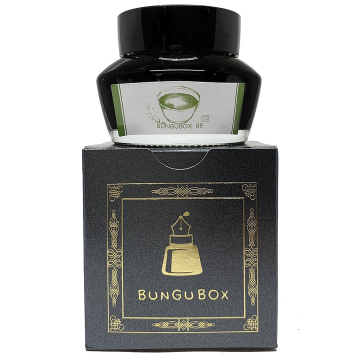 Bungubox 88 - 2ml fountain pen ink in a glass bottle, featuring a green illustration, atop a black box with gold-foil pen-nib motif.