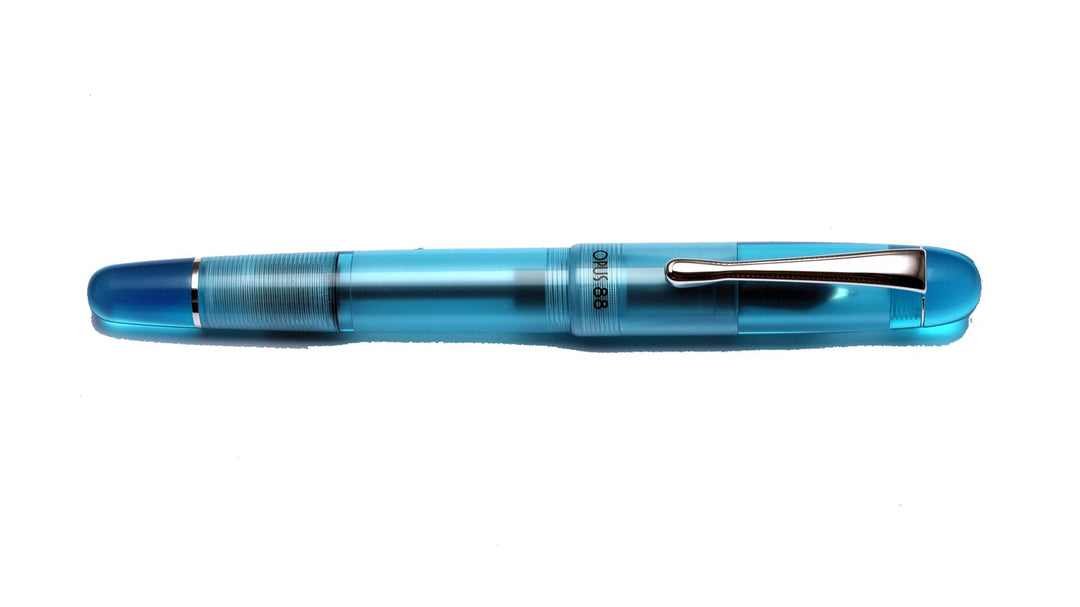 Picnic - Blue (Fine) translucent fountain pen, clear barrel and cap, threaded grip, silver clip, showcasing ink inside. Includes a 
