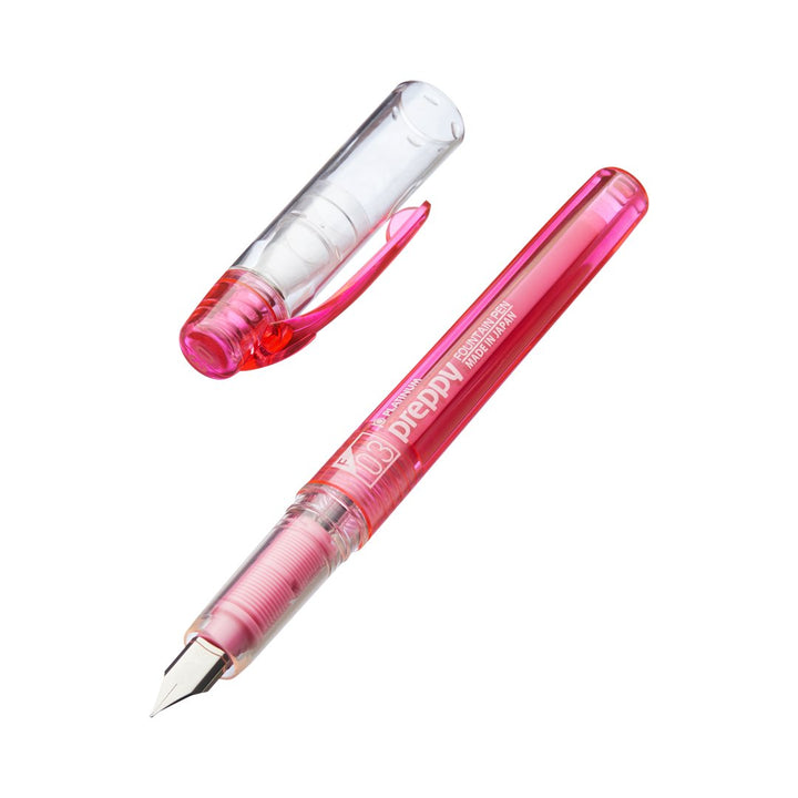 Platinum Preppy - Fine (Pink) fountain pen with translucent body, featuring a visible metal nib and plastic grip section, with cap removed and placed beside the pen.