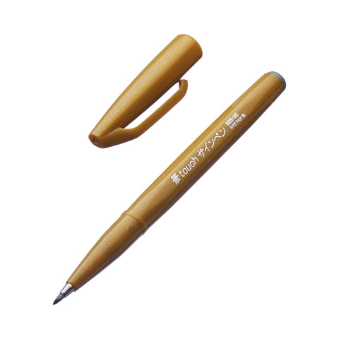 Fude Touch Brush Sign Pen - Yellow Ochre, metallic-bronze with flexible brush nib, cap off, ideal for calligraphy and illustrations. Japanese label visible.