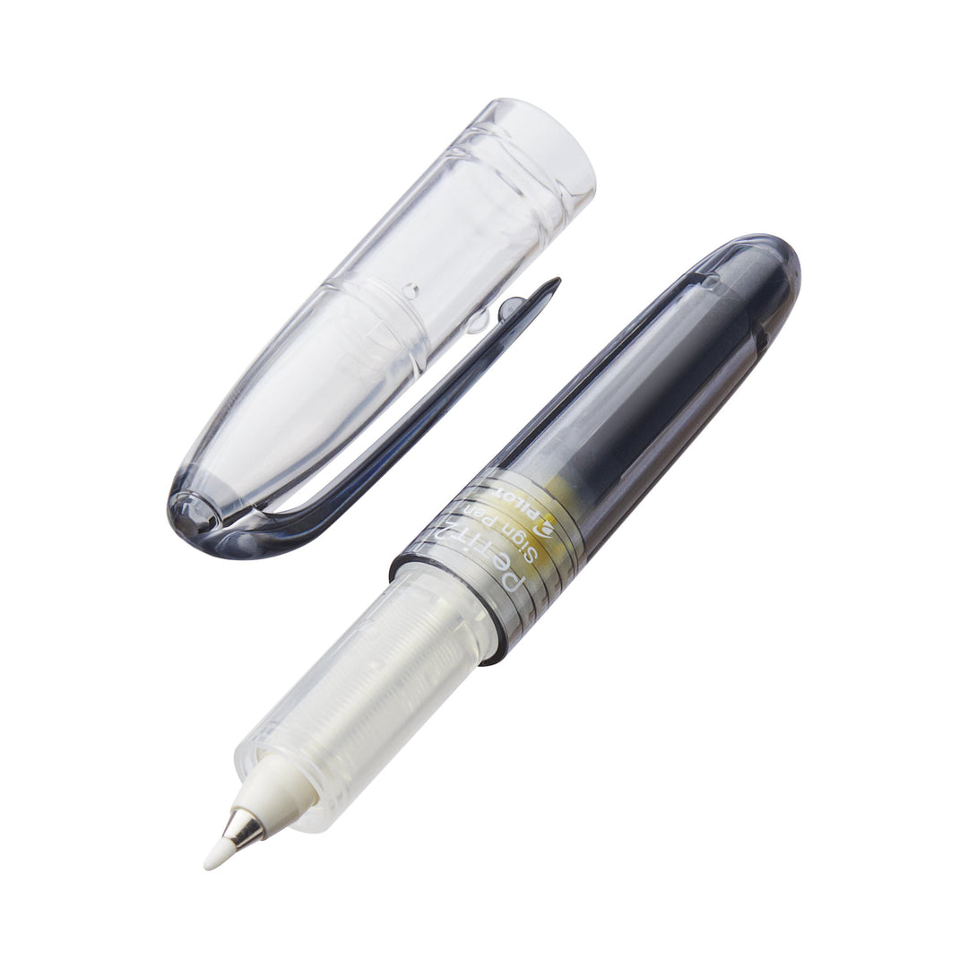 Petit2 Mini Sign Pen - Medium (Black) shown with translucent cap removed, revealing semi-smoke-tinted body, visible ink reservoir, and white-tipped medium bullet felt nib.
