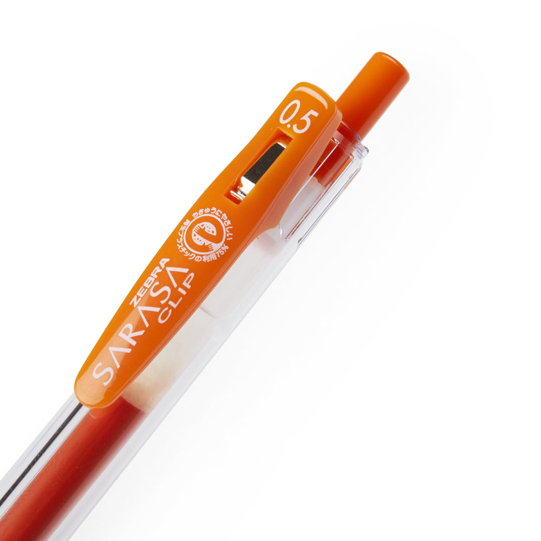 Close-up of an orange Zebra Sarasa Clip pen from the 20 Colour Set, featuring a translucent barrel, 0.5 mm nib, and spring-loaded clip.