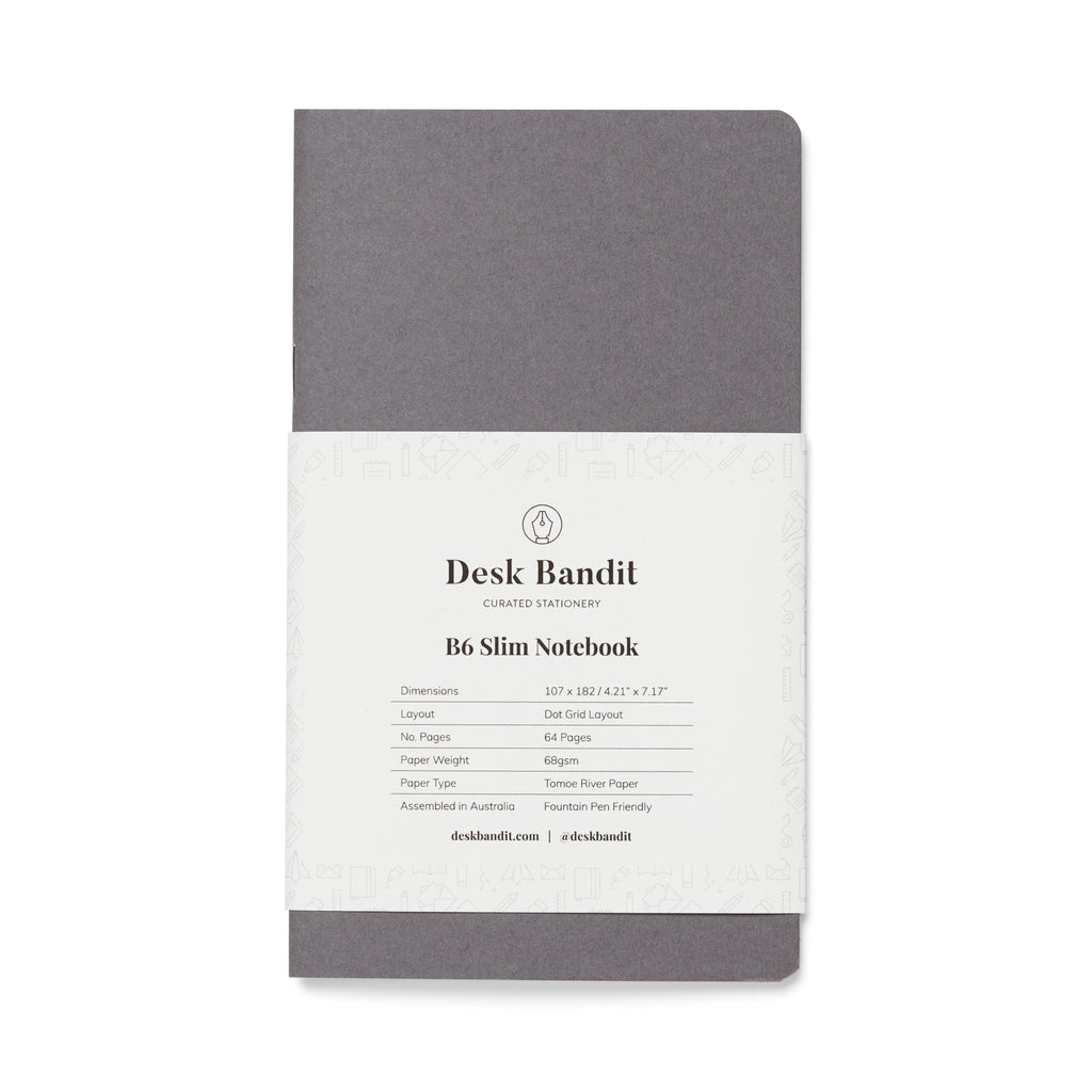 Japanese-Milled 64gsm Notebook - B6 Slim (Dot Grid) with dark gray soft cover, white paper band, and 64 pages of fountain pen friendly paper.