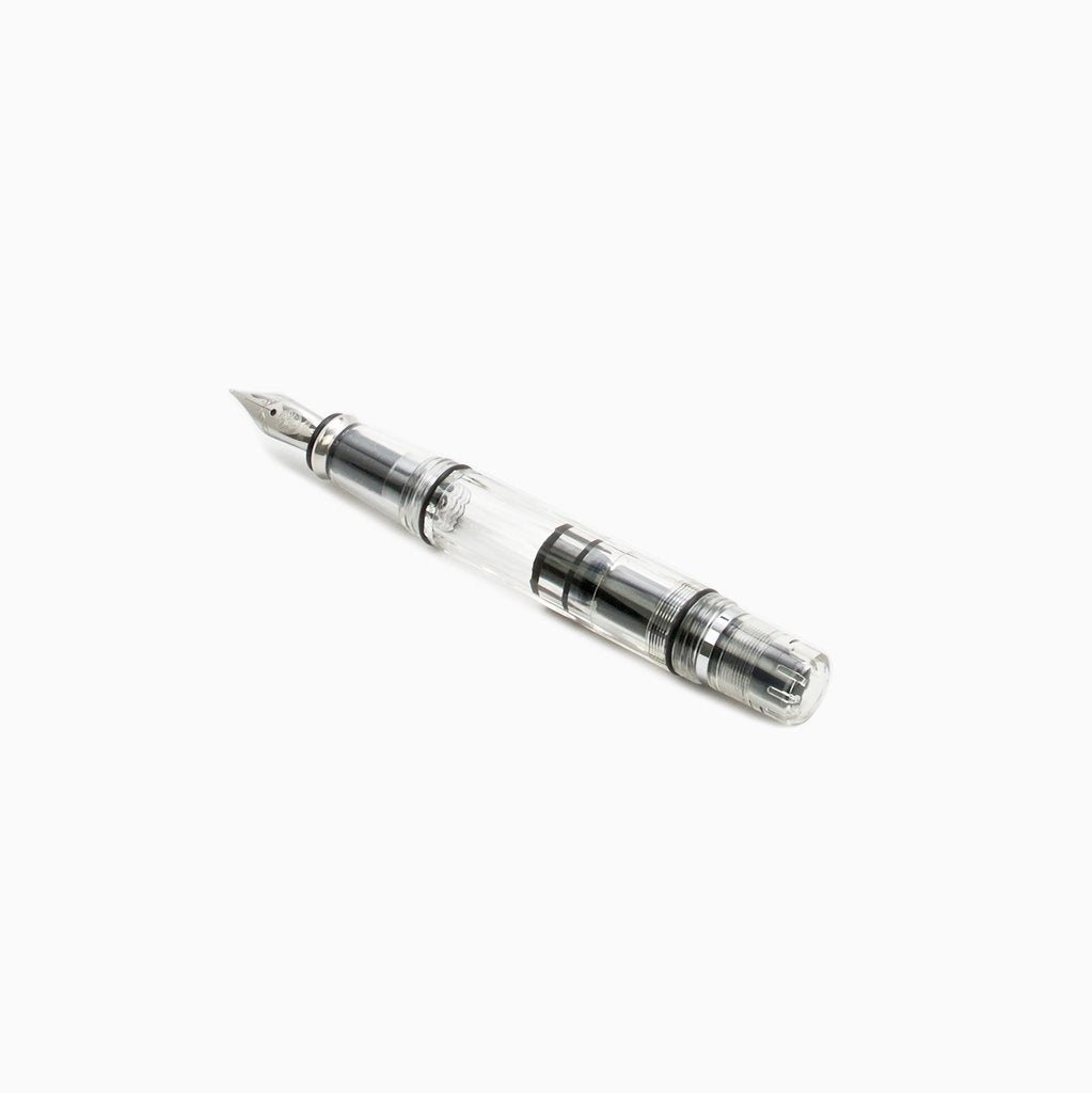 Diamond Mini (Clear) - Extra Fine fountain pen with a transparent barrel and cap, showcasing a piston-style ink reservoir and metal nib, ideal for portability.