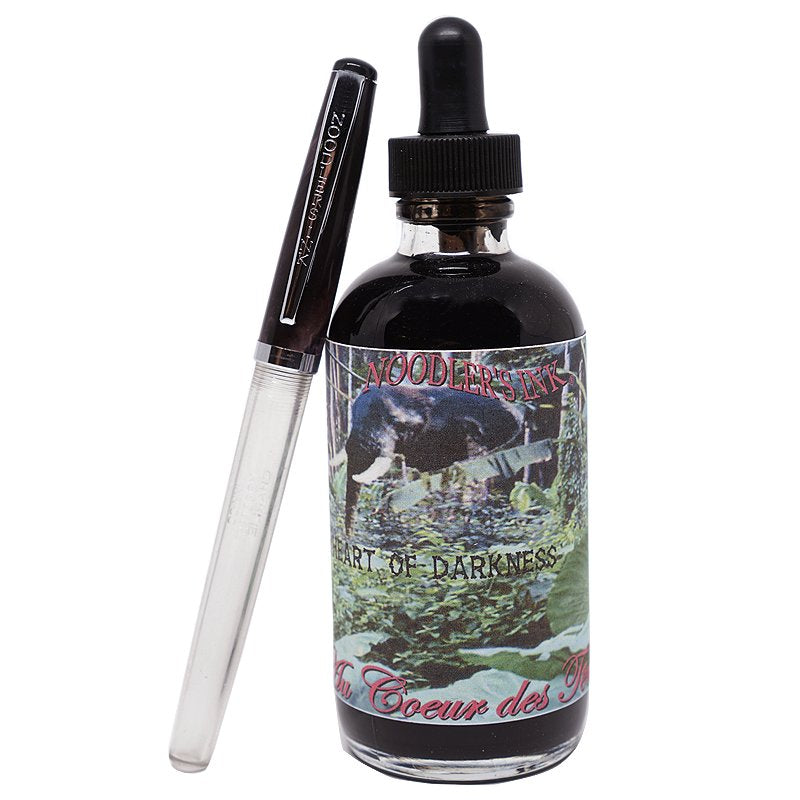 Bottle of Noodler’s Heart of Darkness fountain-pen ink with jungle-themed label, accompanied by a clear-barrel fountain pen, 133ml size.