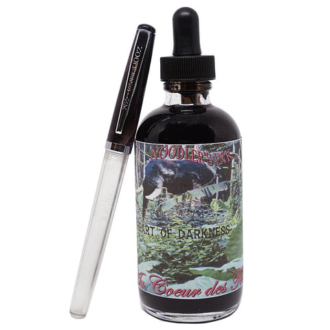 Bottle of Noodler’s Heart of Darkness fountain-pen ink with jungle-themed label, accompanied by a clear-barrel fountain pen, 133ml size.