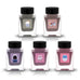 Tono & Lims Gachapon Series Season 6 fountain pen ink bottles featuring five inks with whimsical character labels, including a cat, colorful dog with rocket backpack, owl in space capsule, snake in robot suit, and blue creature in a dinosaur suit, displayed in square glass bottles with black caps